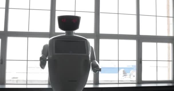 Tecnologías robóticas modernas. El robot mira a la cámara a la persona. El robot muestra emociones. Levanta las manos, baila o se indigna. O ataques — Vídeo de stock