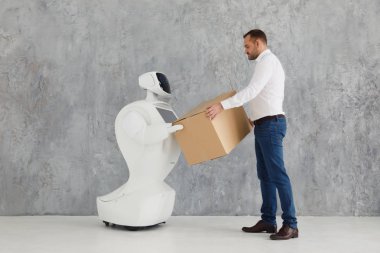 Modern Robotik teknolojiler. Bir adam bir robot, karton kutu el ile iletişim kurar. teslimat kavramı.