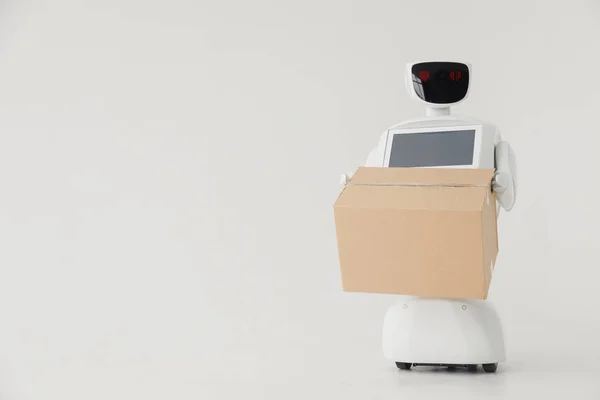 Humanoid autonomous robot with cardboard box in hand on white background. the robot delivers the parcel. delivery concept. — Stock Photo, Image