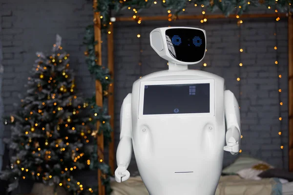 Humanoid autonomous robot on the background of Christmas decorations, Christmas tree, bokeh