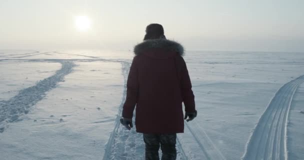 Giovane viaggiatore passa attraverso una bufera di neve al bel tramonto. Spedizione polare — Video Stock