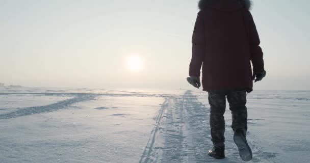 Jovem viajante passa por uma nevasca ao pôr-do-sol bonito. Expedição polar — Vídeo de Stock