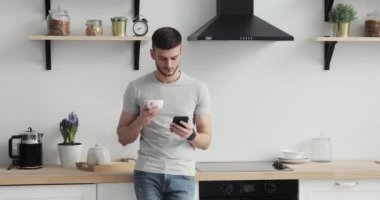 Mutfak üzerinde kalmak ve cep telefonu evde tarama beyaz adam.
