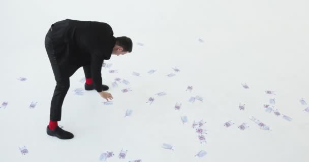 Affärsman samlar dollar från golvet. vit bakgrund — Stockvideo