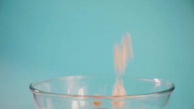 Popcorn mavi arka planda cam şeffaf bir kase içine doldurulur.