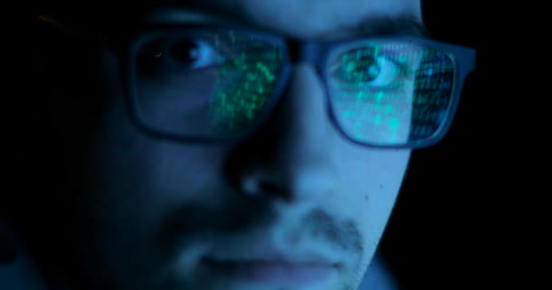 Data code reflection in programmers, hackers glasses. Man is looking at camera. — Stock Video