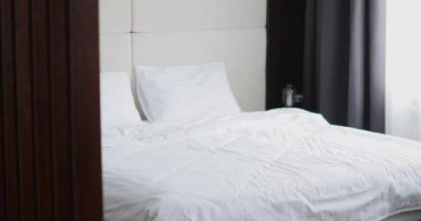 Ofis kıyafetleri yorgun işadamı oturur ve bir otel odasında yatağa düşüyor.