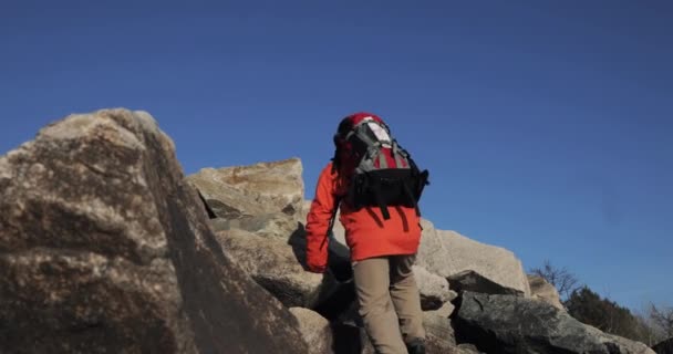 L'homme grimpe au sommet de la falaise. Gagnant lève les mains au fond du ciel heureux de son ascension . — Video