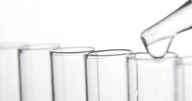 Laboratuar testi, pipet, şeffaf kimyasalları test tüplerine koyarlar.