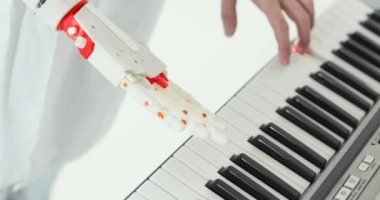 Bilim adamı mühendisi, doğru tuşlara basmaya çalışan piyanoyu oynayan robotik protez el tadıdır.