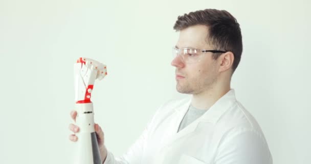 Ingenieur-Wissenschaftler untersucht und testet Roboterprothesen-Hand, die programmierte Bewegungen mit Fingern macht. — Stockvideo