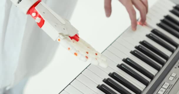 Wetenschapper ingenieur is proeverij robot prothese hand het spelen van de piano proberen om de juiste toetsen druk. — Stockvideo