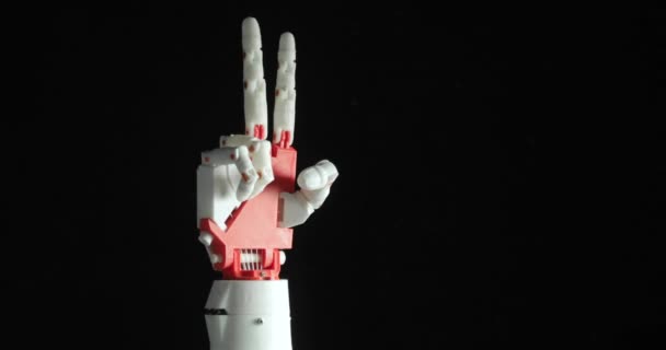 Robotické naprogramované ruční protézy zobrazují rockové gesto a znak vítězství na černém pozadí. — Stock video