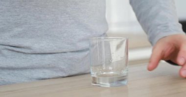 Robotik protez el ile adam şişe cam su dökme ve mutfakta içme.