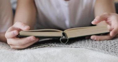 Adam başka bir insan, closeup görünümü yanında yatakta yatan bir kitap okuyor.