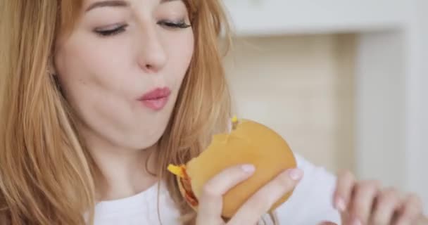 Portrait de jeune femme souriante mange hamburger . — Video