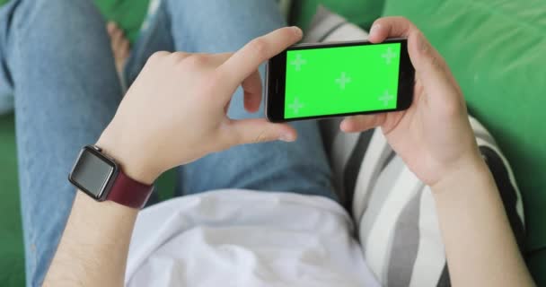 Mobiele telefoon met horizontaal groen scherm in Mans handen. — Stockvideo