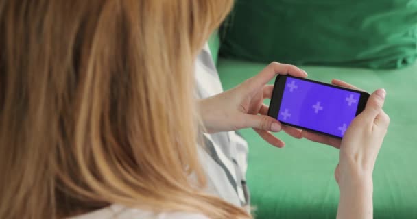 Femme utilise un téléphone mobile avec écran horizontal violet chroma clé, téléphone et mains gros plan . — Video