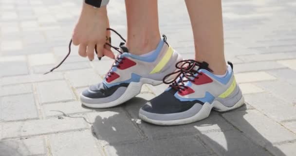 Woman ties shoelaces and runs for jogging, feet closeup. — Stock Video