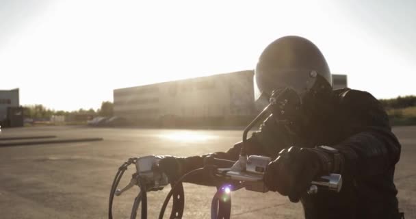 Portret van de jonge man Biker op zijn motorfiets gaan rijden op de weg in de stad. — Stockvideo