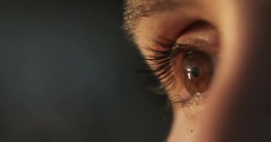 Bulanıklık arka planda kahverengi göz kırpma kadın closeup, yan görünüm.