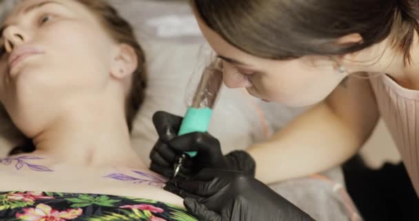 Professionale maestro ragazza pittura tatuaggio con foglie, primo piano vista . — Video Stock