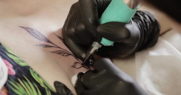 Δάσκαλος τατουάζ είναι ζωγραφική λεπτομέρειες της εικόνας στη μηχανή χρήσης του δέρματος, τα χέρια κοντινό. — Αρχείο Βίντεο