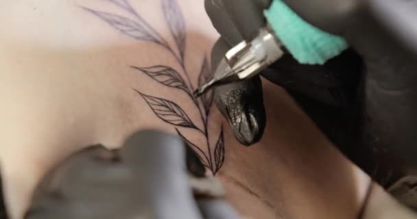 Ο αφέντης Tatto τελειώνει για να ζωγραφίσει τατουάζ στο δέρμα χρησιμοποιώντας το μηχάνημα, τα χέρια κοντινό. — Αρχείο Βίντεο