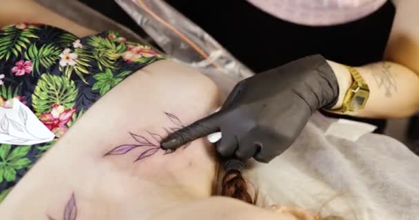 Tatuaggio simmetrico di finitura master tatuaggio sulle spalle delle donne che lavorano nel salone . — Video Stock