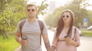 Şehirde yürüyen ve sarılma çift hipsters adam ve hamile kadın Portresi.