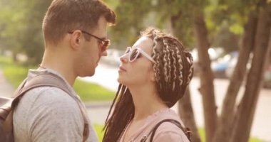 Sokakta güneş gözlüğü genç çift erkek ve kadın öpüşme Portresi.