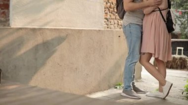 Evin yakınındaki sokakta genç çift erkek ve kadın Öpüşme, yan görünüm.