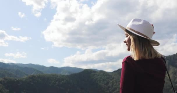 Jovem mulher caminhante turista em chapéu admirando vista incrível no vale das montanhas . — Vídeo de Stock