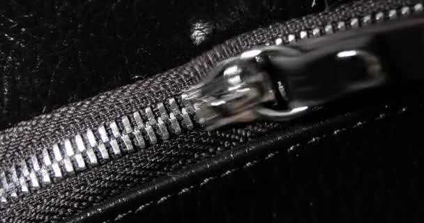 Άντρας φερμουάρ και unzips μέταλλο φερμουάρ μια δερμάτινη μαύρη τσάντα, χέρι closeup άποψη. — Αρχείο Βίντεο