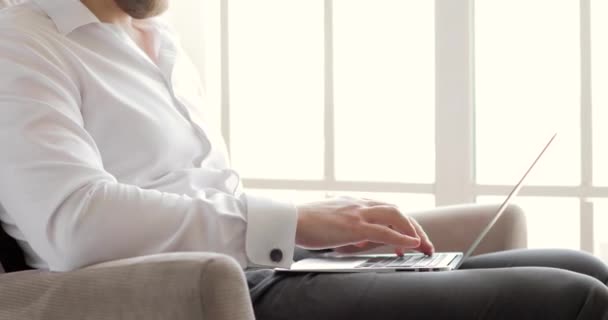 Mains d'homme d'affaires tapant un message sur un ordinateur portable travaillant dans le bureau près de la fenêtre . — Video