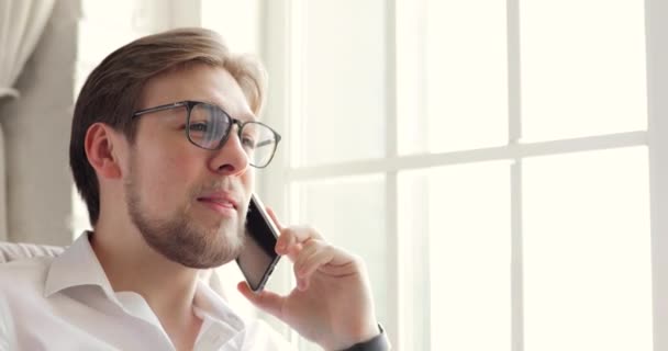Portret młodego mężczyzny freelancer mówiący na smartfonie siedzącym w biurze. — Wideo stockowe