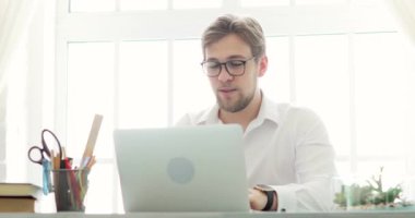 İşadamı ofis çalışanı, modern ofisteki masada dizüstü bilgisayarla yazı yazıyor..