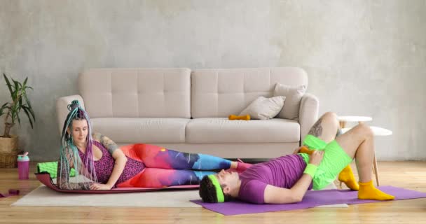 Hombre y mujer haciendo ejercicios de fitness en esteras juntos en la sala de estar en casa . — Vídeo de stock