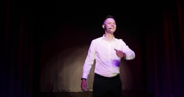 Jeune homme debout humoriste parlant blagues dans microphone debout sur scène. — Video