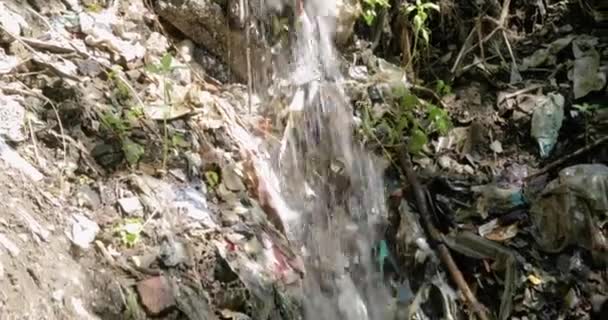 Air terjun dan aliran dengan limbah air limbah dan sampah di sekitarnya di hutan. — Stok Video