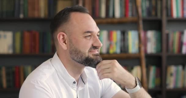 Portrait of a graying man entrepreneur, professor on bookshelves background. — Stock Video