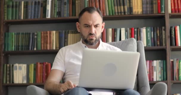Ώριμο αφεντικό άνθρωπος σε απευθείας σύνδεση σε σύνδεση βίντεο ορκίζεται σε εργαζόμενο σε βιβλιοθήκες φόντο. — Αρχείο Βίντεο