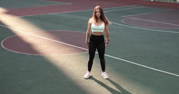 Jeune femme sportive faisant squats sur le campus de l'Université, vue de face. — Video