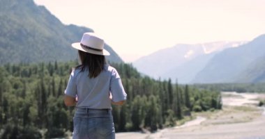 Kadın dağların güzel manzarasına hayran ve çay içiyor..