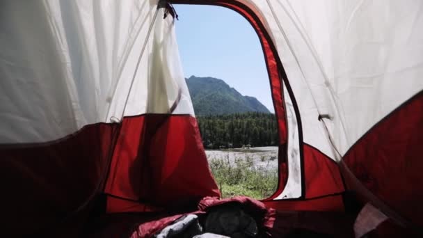 Kamera blickt im Sommer vom Zelt auf den Berg mit Blick auf den Fluss. — Stockvideo