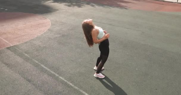 Atletisk kvinna gör yoga hjul pose öva på stadion och står upp. — Stockvideo
