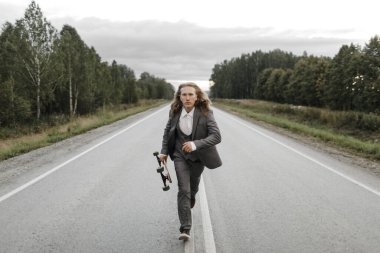 Ofis kıyafetli yakışıklı adam şehrin varoşlarında uzun bir yolda yürüyor..