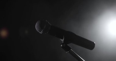 Sahnedeki profesyonel konser mikrofonunun yakın görüntüsü karanlıkta..