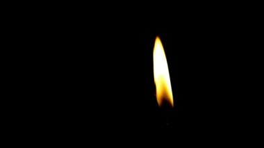 Siyah arkaplanda mum yakılıyor.