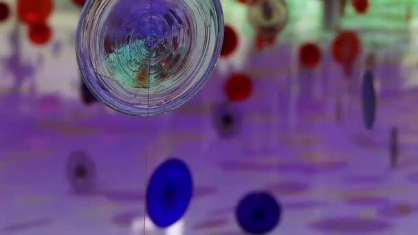 Multicolored glass circles are suspended on ropes in form of an ornament. — Stock Video